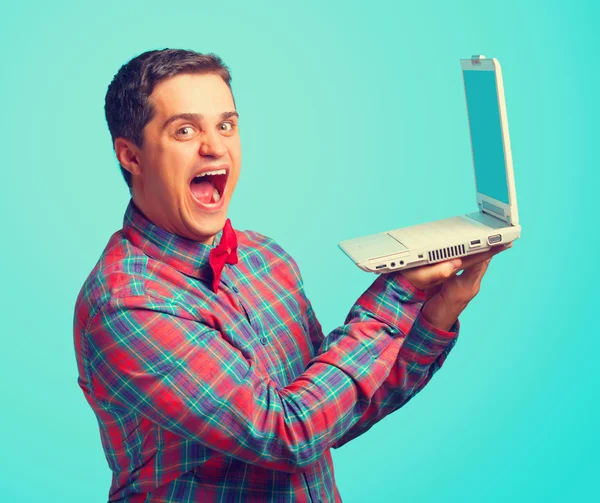 Bonito homem com laptop no fundo azul . — Fotografia de Stock