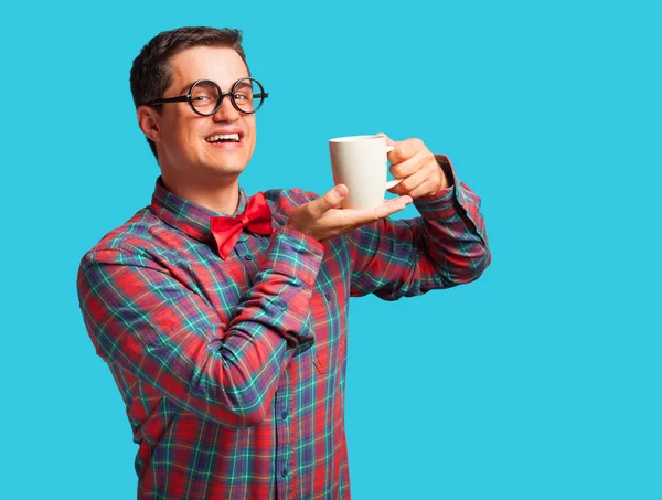 Nerd com xícara de café no fundo azul . — Fotografia de Stock