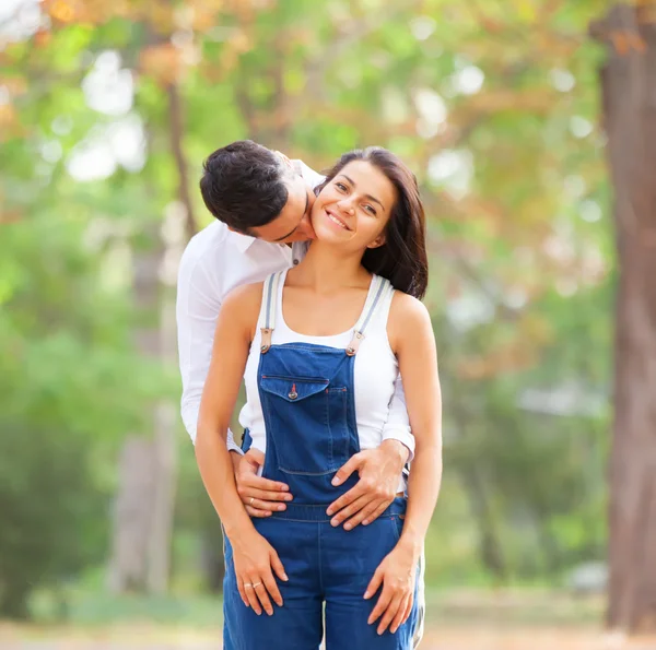 Teen couple kissing in the park in autumn time — Stock Photo, Image