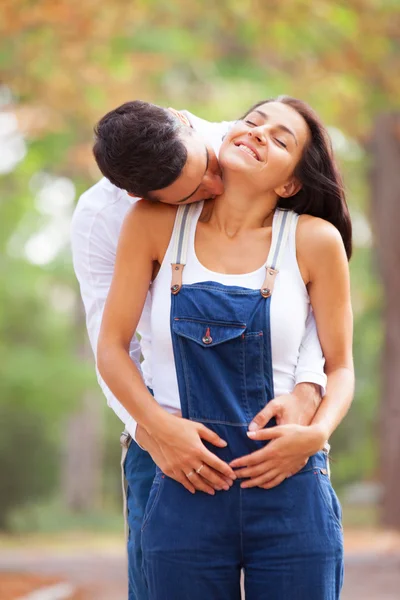 Teen couple kissing in the park in autumn time — Stock Photo, Image