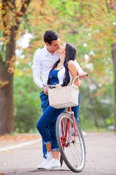Teen par med retro cykel kyssar i parken i höstens tid — Stockfoto