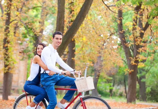 Genç çift parkta bir sonbahar zaman bisiklet ile — Stok fotoğraf