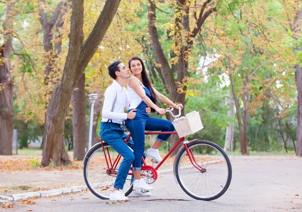 Pareja adolescente con bicicleta en el parque en otoño —  Fotos de Stock