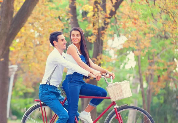 Teen pár s kolo v parku v podzimním čase — Stock fotografie