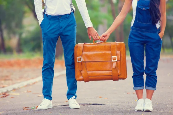 Couple holding suitcase in the park. — Stock Photo, Image