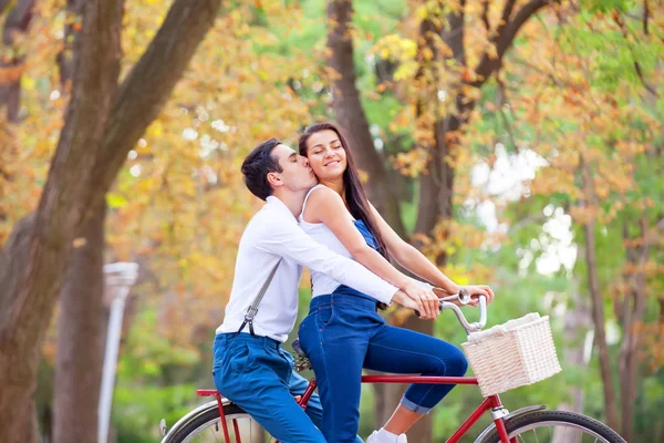 Adolescente casal com bicicleta retro beijando no parque no outono — Fotografia de Stock