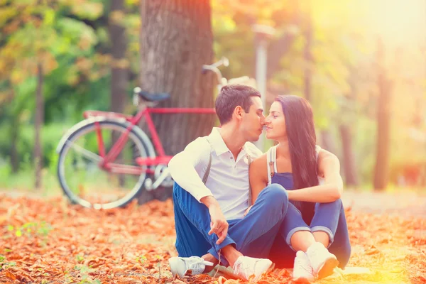 Adolescente casal com bicicleta retro beijando no parque no outono — Fotografia de Stock