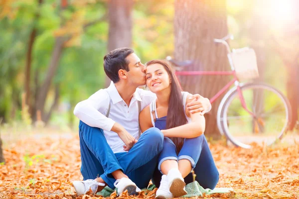 Pareja adolescente con bicicleta retro besándose en el parque en otoño — Foto de Stock