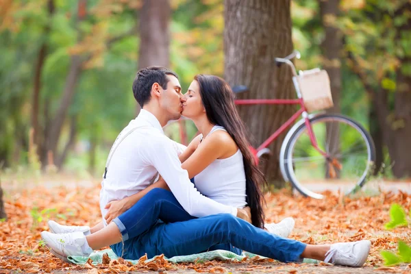 Pareja adolescente con bicicleta retro besándose en el parque en otoño — Foto de Stock