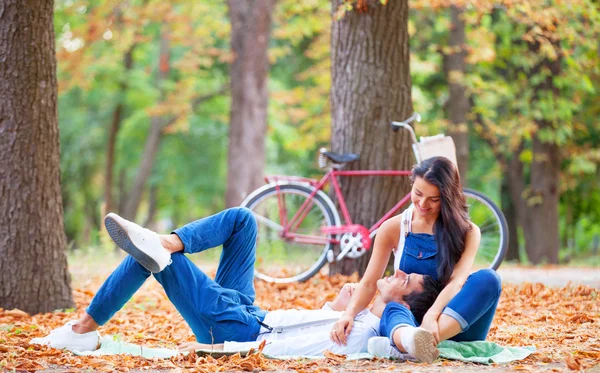 Teen couple with bike in the park in autumn time — Stock Photo, Image