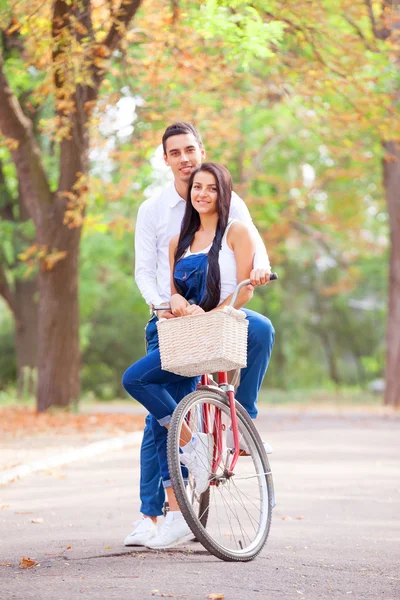 Teen couple with bike in the park in autumn time — Stock Photo, Image