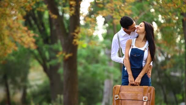 Подростковая пара с поцелуями на ретро-байке в парке осенью — стоковое видео