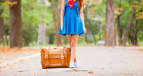 公園でスーツケースと美しい赤毛の女の子. — ストック写真