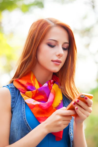 Beautifu girl with mobile phone in the park. — Stock Photo, Image