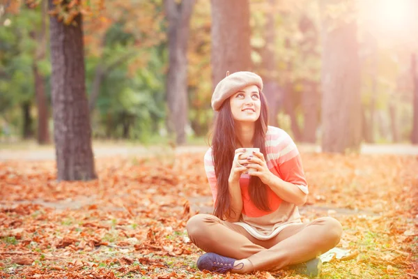 Mooi brunette meisje met kopje in het park. — Stockfoto