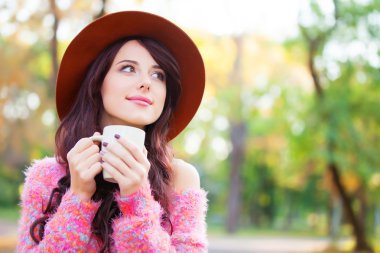 Sonbahar parkta kahve ile esmer kız.