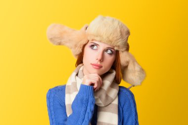 Sarı arka plan üzerinde şapkalı Kızıl saçlı kız.