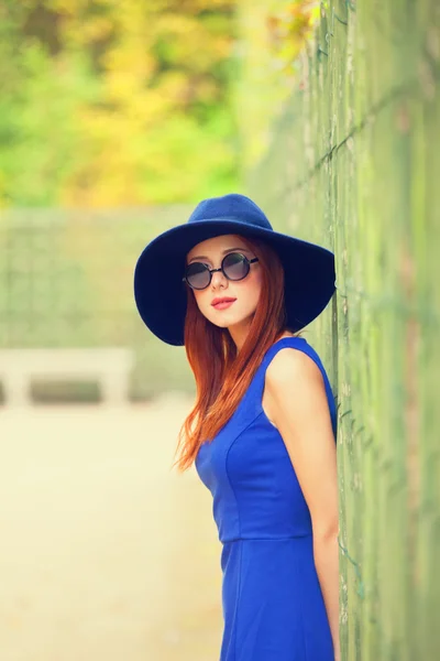 Menina ruiva em óculos de sol perto de cerca no jardim de Versalhes — Fotografia de Stock