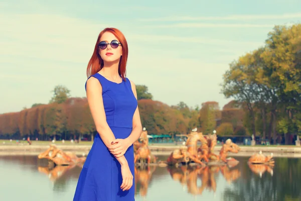 Rothaariges Mädchen mit Sonnenbrille in der Nähe eines Sees in Versailles — Stockfoto