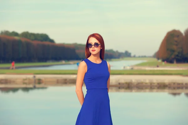 Menina ruiva em óculos de sol perto do lago em Versalhes — Fotografia de Stock