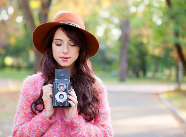 秋の公園でカメラを持つ美しい赤毛の女性. — ストック写真