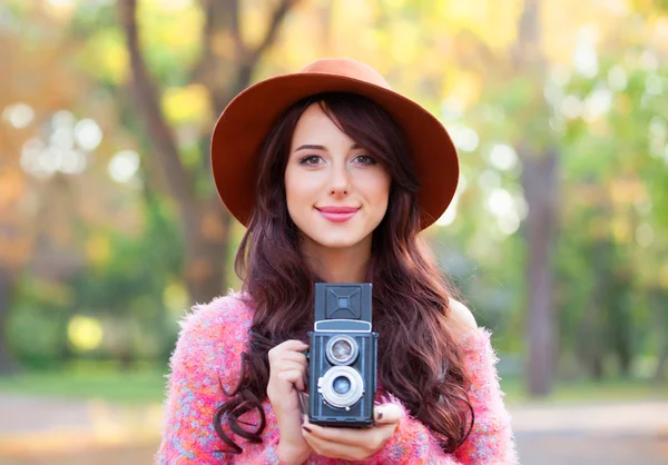 Mooie roodharige vrouwen met camera in de herfst park. — Stockfoto