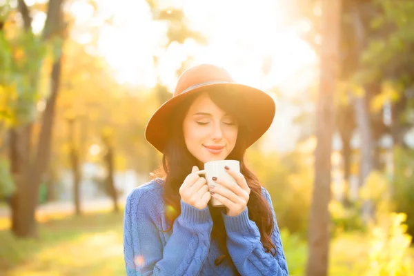 Brunette meisje met kop in het park op zonsondergang tijd — Stockfoto