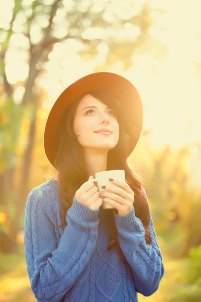 Chica morena con taza en el parque en la hora de la puesta del sol —  Fotos de Stock