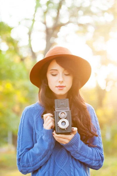 Brunetka s kamerou v parku v čas západu slunce — Stock fotografie