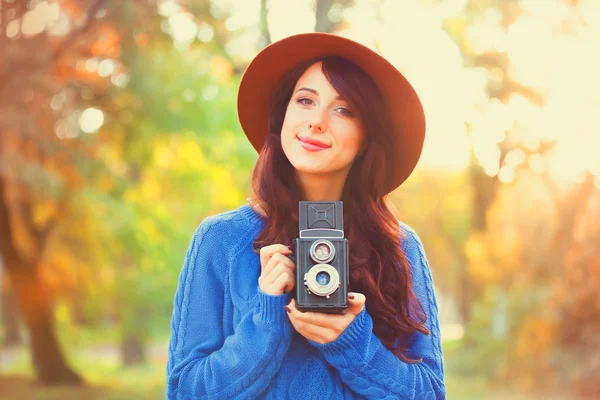 Brunetka s kamerou v parku v čas západu slunce — Stock fotografie