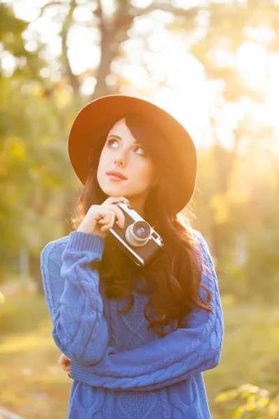 Brunetka dziewczynka z aparatu w parku w zachód słońca — Zdjęcie stockowe