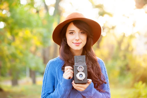 Brunetka s kamerou v parku v čas západu slunce — Stock fotografie