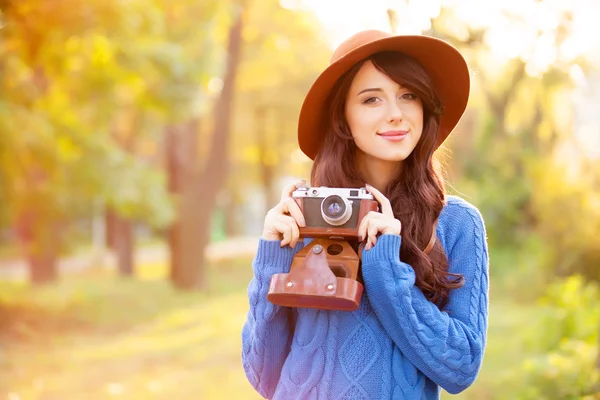 Brunetka s kamerou v parku v čas západu slunce — Stock fotografie