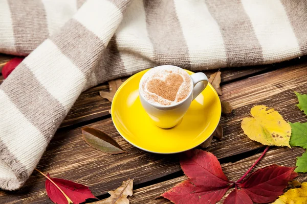 Herbstblätter, Schal und Kaffeetasse auf Holztisch. — Stockfoto