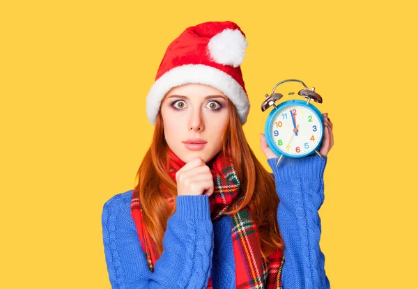 Menina ruiva com despertador no fundo amarelo . — Fotografia de Stock