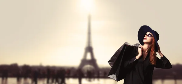 Femme rousse avec des sacs à provisions sur fond parisien . — Photo