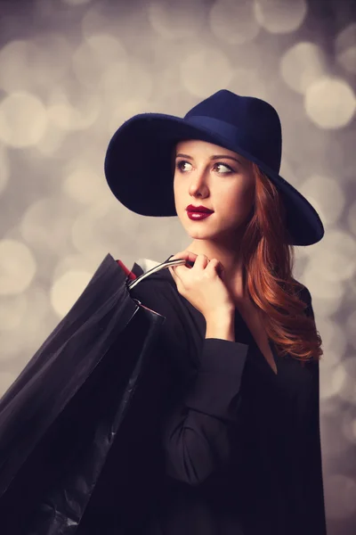 Estilo menina ruiva com sacos de compras . — Fotografia de Stock