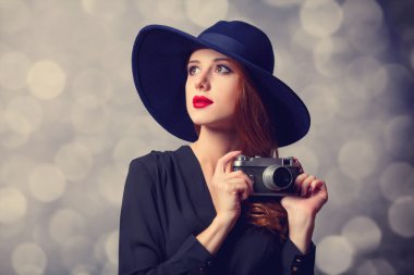 Kızıl saçlı kadın güneş gözlüğü ve vintage fotoğraf makinesi ile stil.