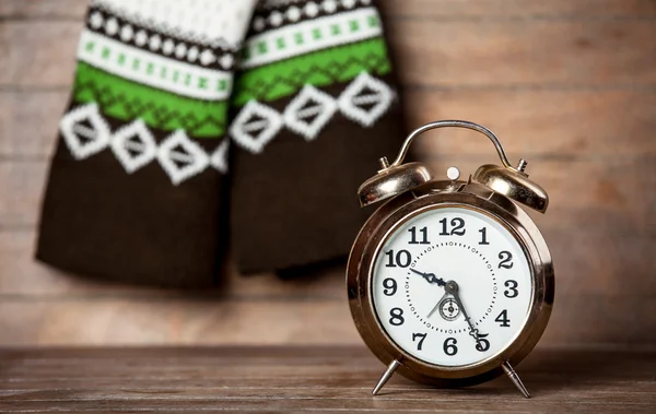 Retro alarm clock and scarf on wooden table. — Stock Photo, Image