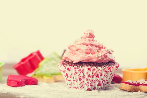 Cupcake with pink cream on a table. — Stock Photo, Image