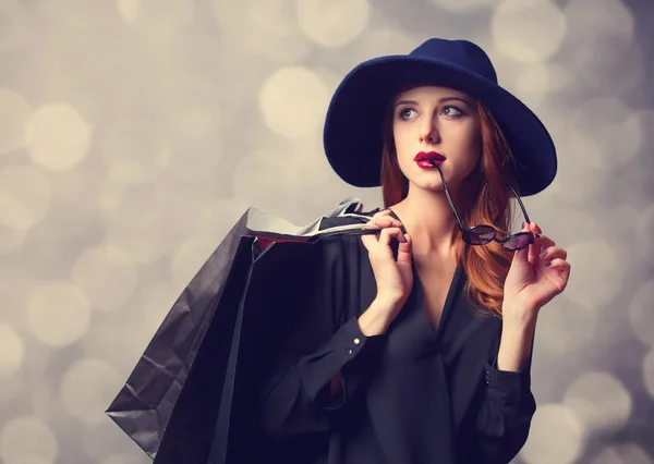 Estilo menina ruiva com sacos de compras . — Fotografia de Stock