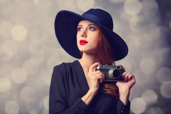 Estilo mujer pelirroja con gafas de sol y cámara vintage . — Foto de Stock