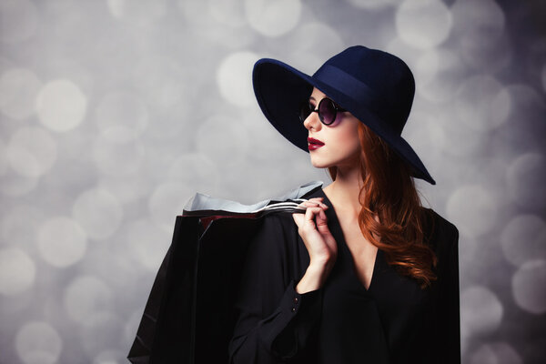 Стильная рыжая девушка в солнечных очках и сумках
.