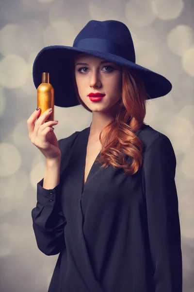 Estilo pelirroja chica en un sombrero celebración de perfume —  Fotos de Stock