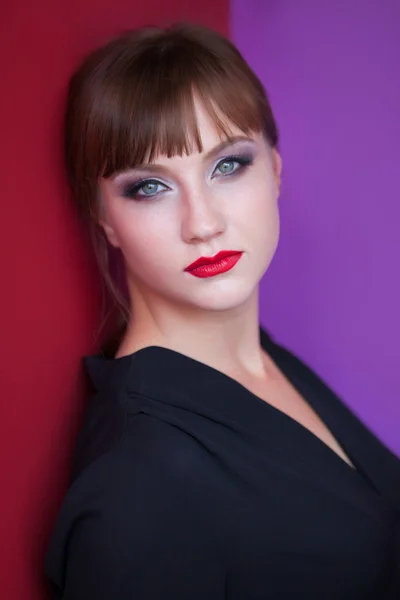 Portrait of bruneette girl on red and violet background — Stock Photo, Image