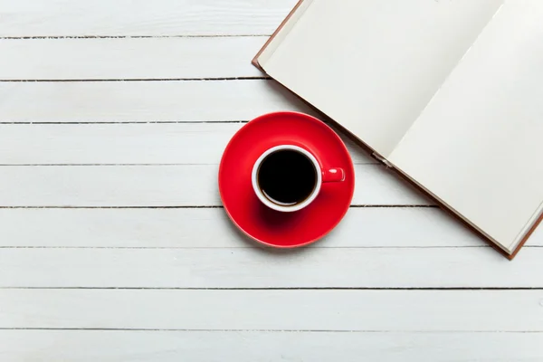 Boek en kopje koffie op houten tafel. — Stockfoto