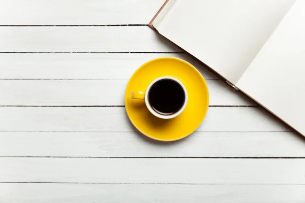 Libro e tazza di caffè sul tavolo di legno . — Foto Stock