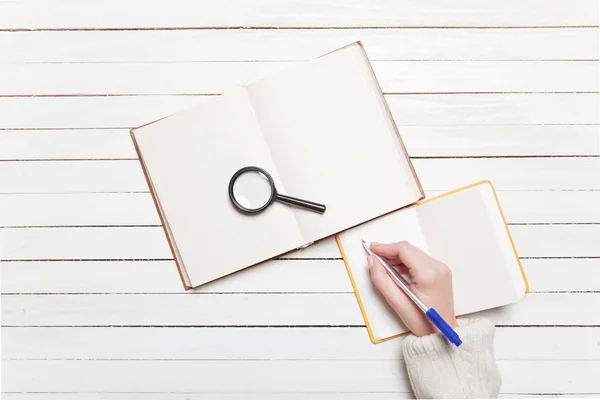 Vrouwelijke hand schrijven iets in om op te merken — Stockfoto