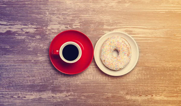 Cup of coffee and donut on a table. — Stock Photo, Image