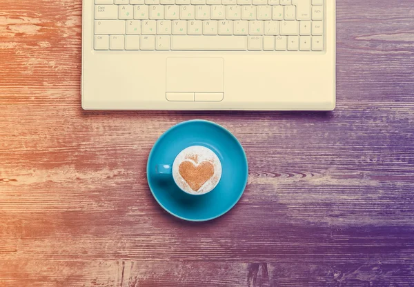 Fincan kahve ve bir masa üstünde laptop. — Stok fotoğraf